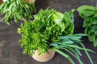 Yeşil soğan, ıspanak, maydanoz ve dereotu. Vitamin yiyeceği. Salata için sebze hazırlayın. Yeşil borş için farklı yapraklar ayır