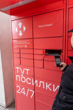 NOVA POSHTA paket terminalinden posta alınıyor. Temassız gönderme ve gönderme. Ukrayna, Kyiv - 23 Mart 2024