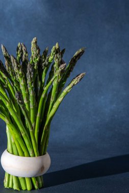 Bir sürü yeşil kuşkonmaz. Taze bahar sebze buketi. Siyah arkaplan kopyalama alanı