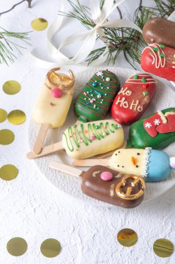 Christmas dessert. Sweet food. Cheesecake on a stick in the shape of ice cream. Childrens treat in winter. Candy Christmas tree, snowman, deer and Santa Claus. Gingerbread cookies. clipart