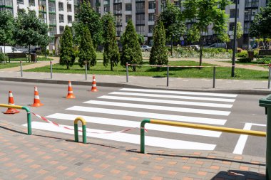 Yol işaretleri uygulanıyor. Avluda yaya geçidi var. Koniler