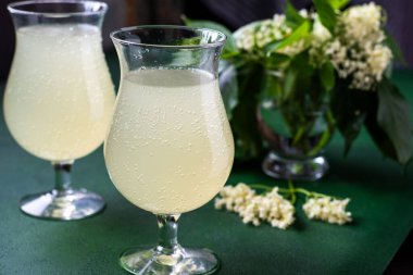 Karbonatlı mürver çiçeği içeceği. Gözlüklü yaz kvass 'ı. Ev yapımı köpüklü hugo suyu. Çiçek arka planı