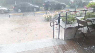 Yağmur, gök gürültüsü ve dolu evin verandasında. Güçlü fırtına kasırgası. Şehirde kötü hava var. Fırtına.