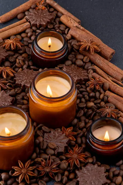 Kavanozda soya kokulu mum. Kahve çekirdekleri, anason, tarçın baharatları. Mumlar yanıyor. Koyu arkaplan