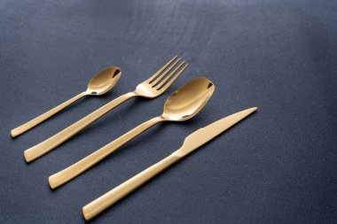 Altın metalden yapılmış çatal bıçak takımı. Çatal, kaşık, bıçak, çay kaşığı