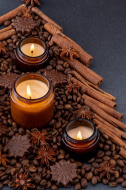 Kavanozda soya kokulu mum. Kahve çekirdekleri, anason, tarçın baharatları. Mumlar yanıyor. Koyu arkaplan