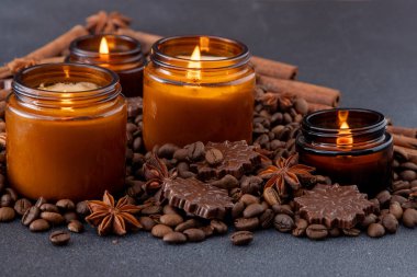 Kavanozda soya kokulu mum. Kahve çekirdekleri, anason, tarçın baharatları. Mumlar yanıyor. Koyu arkaplan