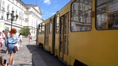 Yazın sarı tramvay şehri. Ulaşım için açık hava reklamı. Ağır çekim. Ukrayna, Lviv - 12 Ağustos 2024