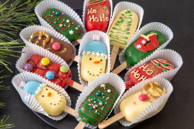 Christmas dessert. Sweet food. Cheesecake on a stick in the shape of ice cream. Kids treat in winter. Candy Christmas tree, snowman, deer and Santa Claus. Gingerbread cookies. clipart