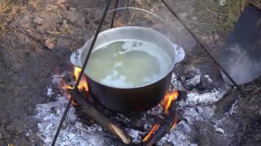 Yangında kazan var. Yürüyüşte yemek pişirmek. Kamp alanında yemek çorbası. Aşırı seyahat turizmi. Yakacak odun