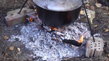 Yangında kazan var. Yürüyüşte yemek pişirmek. Kamp alanında yemek çorbası. Aşırı seyahat turizmi. Yakacak odun