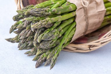 Bir sürü yeşil kuşkonmaz. Taze bahar sebzesi sepette.