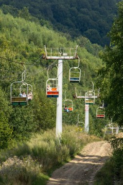 Kayak kaldırma. İnsanlar seyahat eder. Kablodan Carpathian Dağı zirvesine. Hills Ormanı. Doğal yaz nakliyesi. Ukrayna, Slavske - 8 Ağustos 2024