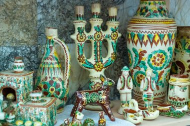 Clay ceramic decor. Kosiv painting. Different old Ukrainian dishes. Decanter, statuette plates set clipart