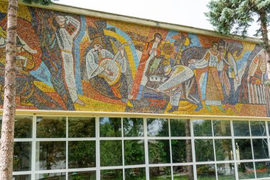 Binanın duvarında mozaik var. Çok renkli fayanslar. Ukrayna evi. İnsanlar duvar resmi yapıyor. Ukrayna, Truskavets - 10 Ağustos 2024