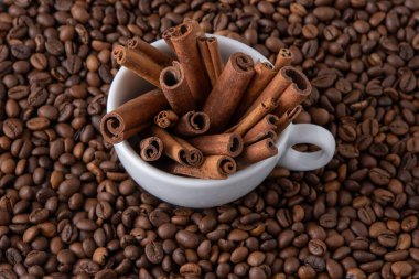 Kahve çekirdekleri ve tarçın çubukları bir fincanda. Gıda arkaplanı
