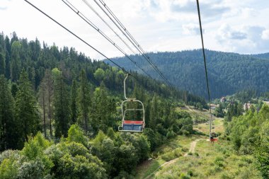 Yeşil ormanda kayak asansörü. Dağlarda Kablo Yolu. Yazın doğa ağaçları