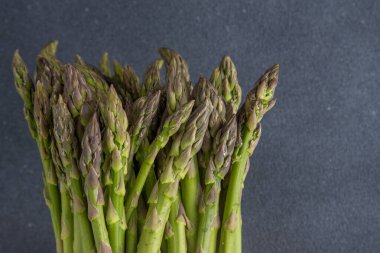 Yeşil kuşkonmaz. Taze bahar sebzeleri. Koyu arkaplan