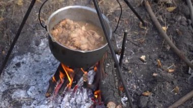 Kazanda ateşte pişmiş et var. Kaynatma ve kızartma. Kamp ateşi turizm yiyeceği.