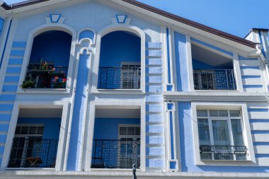 House Buildings 'in mavi renkli modern dış görünüşü balkona bakıyor. Parlak mimari