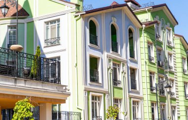 Houses Binaları 'nın çok renkli modern dış görünüşü. Yazın parlak mimari caddesi. Balkon ve Pencereler yeşil mavi