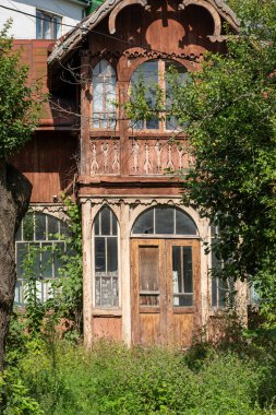 Eski ahşap ev. Dış görünüş. Dış cephe pencereleri. Terk edilmiş eski mimari ev.