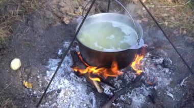 Yangında kazan var. Yürüyüşte yemek pişirmek. Kamp alanında yemek çorbası. Seyahat turizmi aşırı piknik