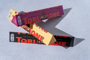Toblerone marka çikolata ambalajı. İsviçre Mondelez çikolatası. Gri gölge arka plan. Üç farklı tat. Ukrayna, Kyiv - 4 Kasım 2024