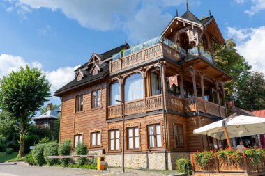 Ahşap bir evin ahşap balkonu. Dış cephe pencereleri. Eski mimari eko evi. Lviv çikolatalı kafe. Ukrayna, Truskavets - 11 Ağustos 2024