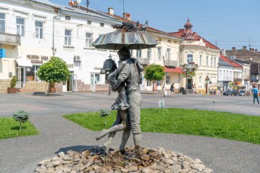 Şemsiye Altında Aşk Çeşmesi. Şehirdeki güvercinler. Su yağmuru yazı. Ukrayna, Drohobych - 13 Ağustos 2024