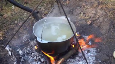 Yangında kazan var. Yürüyüşte yemek pişirmek. Kamp alanında yemek çorbası. Aşırı seyahat turizmi. Yaz kampı