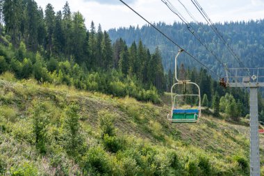 Yeşil ormanda kayak asansörü. Dağlarda Kablo Yolu. Yazın doğa ağaçları