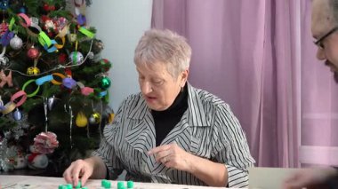 Yaşlı kadın emekli bingo oynuyor. Ailesiyle birlikte Noel ağacının altında masa oyunu oynayan bir büyükanne. Piyango