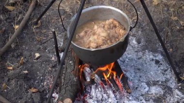 Kazanda ateşte pişmiş et var. Kaynatma ve kızartma. Kamp ateşi açık hava yemeği. Yemek yap.