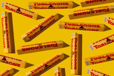 Toblerone marka çikolata ambalajı. İsviçre Mondelez şekeri. Sarı paket arka planı. Üst görüş düzeni. Ukrayna, Kyiv - 4 Kasım 2024.