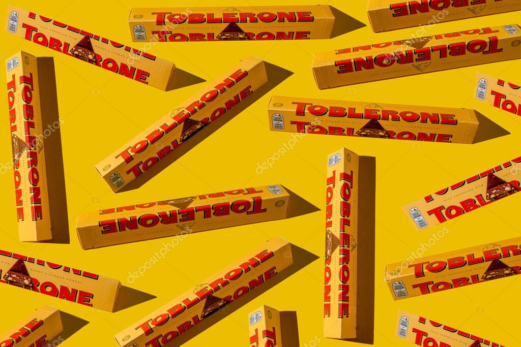 Toblerone brand chocolate packaging. Swiss Mondelez candy. Yellow pack background. Top view pattern. Ukraine, Kyiv - November 4, 2024.