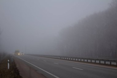 Yolda sis var. Otobanda görüş mesafesi düşük. Otoyoldaki arabalar. Sisli bir gün.