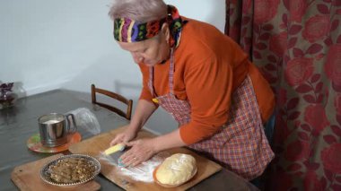 Turta için hamur kesen kadın. Büyükannem evde undan yemek pişiriyor. Masada yemek pişirmek.