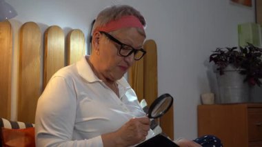 Büyüteçten bakıyorum. Yaşlı bir kadın yatakta oturmuş posta pullarından oluşan bir albüme bakıyor. Büyükanne profili. Evde hobi.