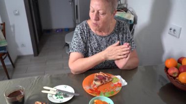 Yaşlı bir kadın pizza yer. Büyükannem mutfakta kahvaltı yapar. Masada. Bir tabak yemek, bir fincan kahve. Pizzanın kenarını kopar..