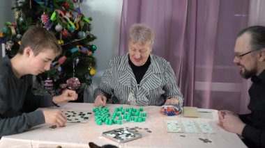 Yaşlı bir emekli kadın bingo oynuyor. Ailesiyle birlikte evde Noel ağacı yakınında masa oyunu oynayan bir büyükanne. Piyango. Birlikte zaman geçirmek