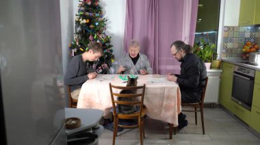 Yaşlı bir emekli kadın bingo oynuyor. Ailesiyle birlikte evde Noel ağacı yakınında masa oyunu oynayan bir büyükanne. Piyango. Birlikte zaman geçirmek. Mutlu kedi