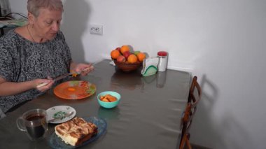 Yaşlı bir kadın fırında kabak yer. Büyükannem evde, mutfak masasında kahvaltı yapar. Sağlıklı bir tabak, bir fincan kahve. Meyve sebze diyeti