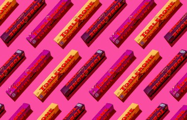 Toblerone marka çikolata. İsviçre Mondelez şekeri. Pembe arkaplan desenli üst görünümde farklı aroma seti. Ukrayna, Kyiv - 4 Kasım 2024.