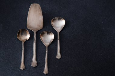 Zarif Silver Serving Utensils Set. Siyah arka planda farklı kaşıklar. Pasta küreği. Boşluğu kopyala