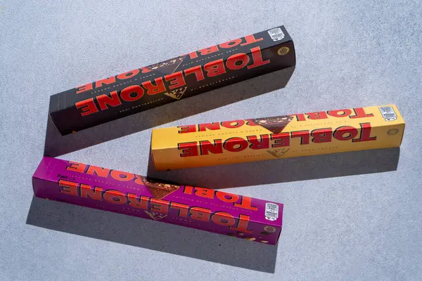 Toblerone marka çikolata ambalajı. İsviçre Mondelez çikolatası gri arka plan manzaralı tatlı yiyecekler. Ukrayna, Kyiv - 4 Kasım 2024