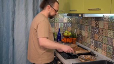 Adam bir spatulayla birlikte bir tepsiye kurabiye koyar. Ev yapımı pişirme. Yemek pişir