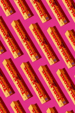 Toblerone çikolatası. İsviçre Mondelez şekeri. Pembe arka plan desenli sarı paket. Ukrayna, Kyiv - 4 Kasım 2024.