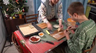Çocuk kurabiye ve turta yapıyor. Mangır çıkarıyorum. Ergen, büyükannenin Noel için yemek yapmasına yardım ediyor. Ev mutfağında yemek pişirmek