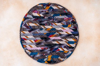 Yamalı yorgan yuvarlak halı. Rengarenk kumaş parçalarının dairesel bir parçası dikilmiş..